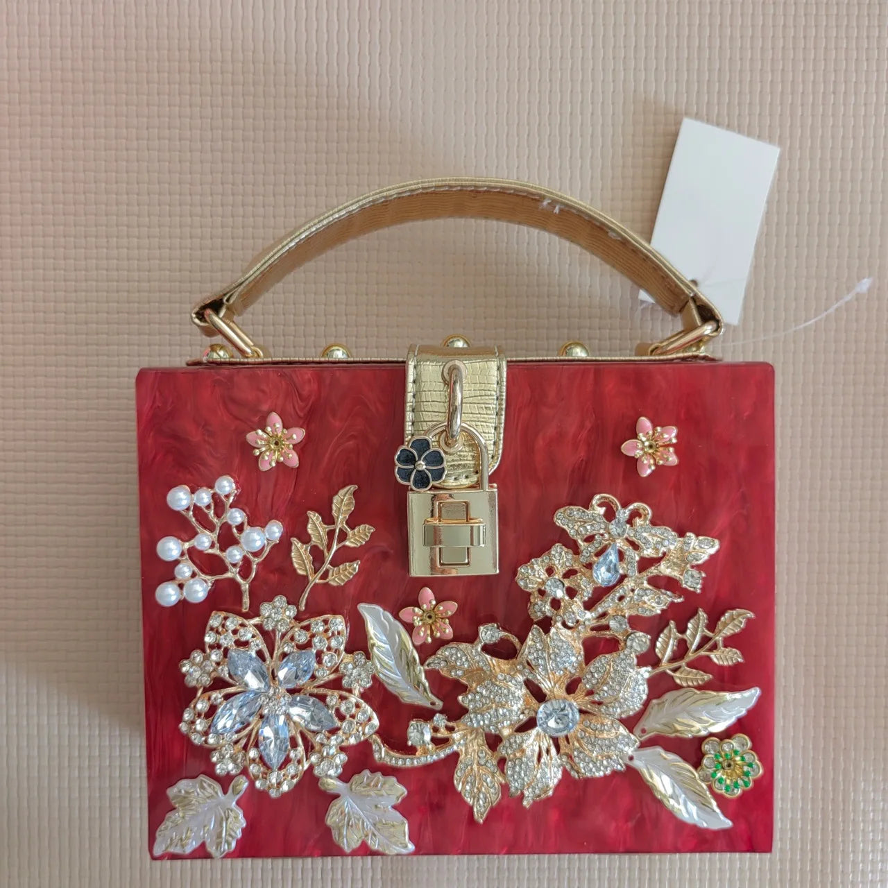 Bolsa Minaudière Metálica com Detalhes em Diamantes e Forro em Couro Sintético.